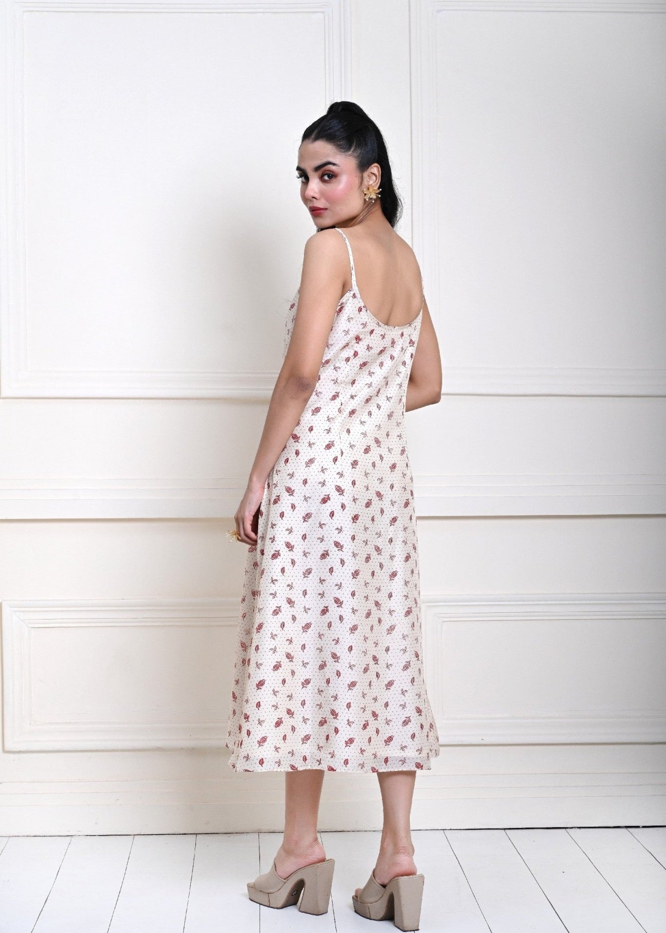 Off-white printed midi dress with a strappy design, perfect for contemporary fashion and day-to-evening transitions.
