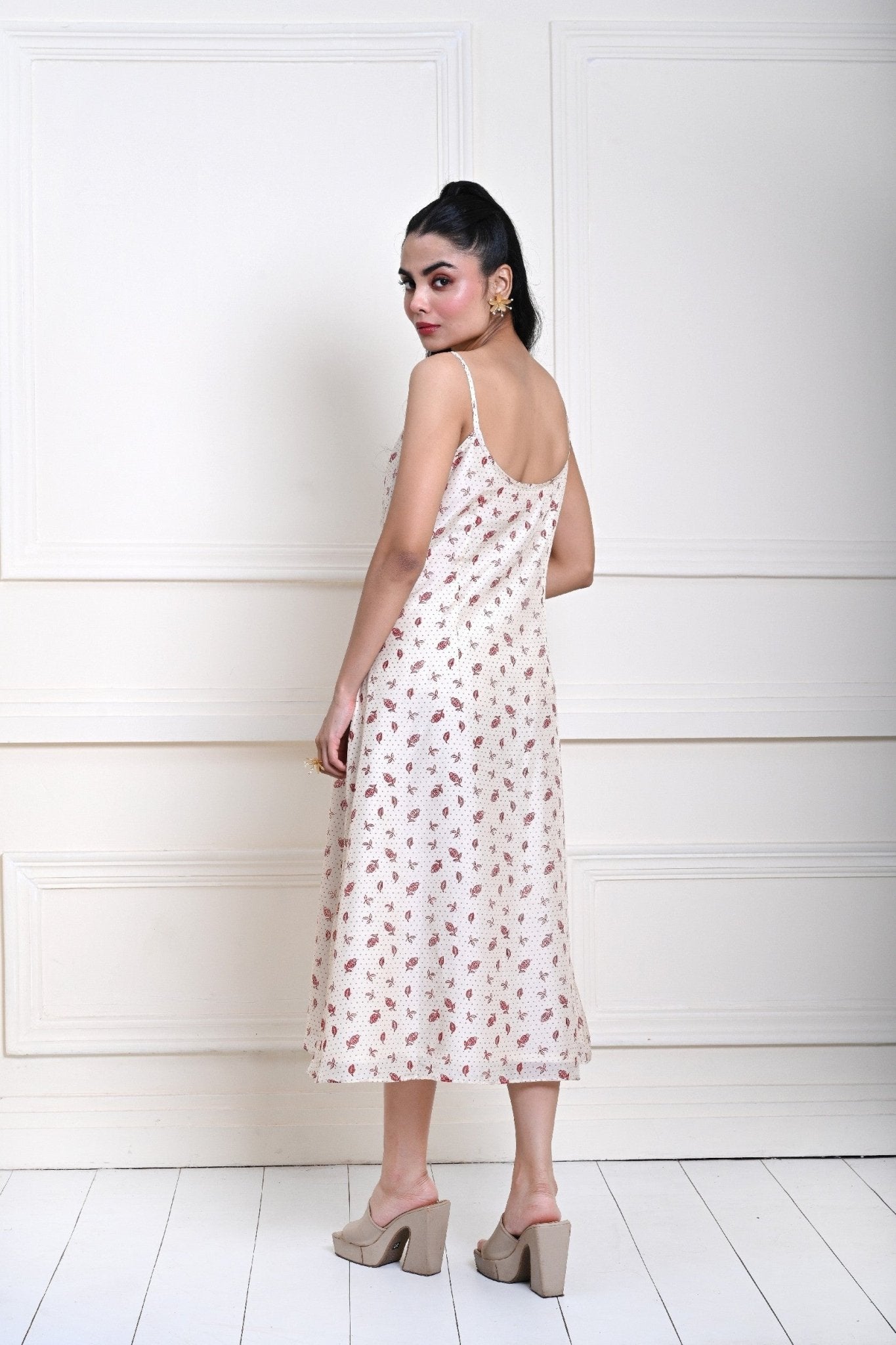 Off-white printed midi dress with a strappy design, perfect for contemporary fashion and day-to-evening transitions.
