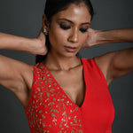 Close-up of intricate hand embroidery on red georgette blouse with V-neckline