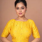 Woman Wearing a Yellow Raw Silk Blouse with Boat Neckline and Gold Floral Work: Anvi Couture - Image 1