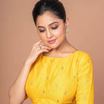 A Woman Wearing a Yellow Raw Silk Blouse with Boat Neckline and Gold Floral Work: Festive Wear Blouse - Anvi Couture - Image 4