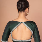 Back view of dark green silk blouse showing pearl-studded cut-out back design