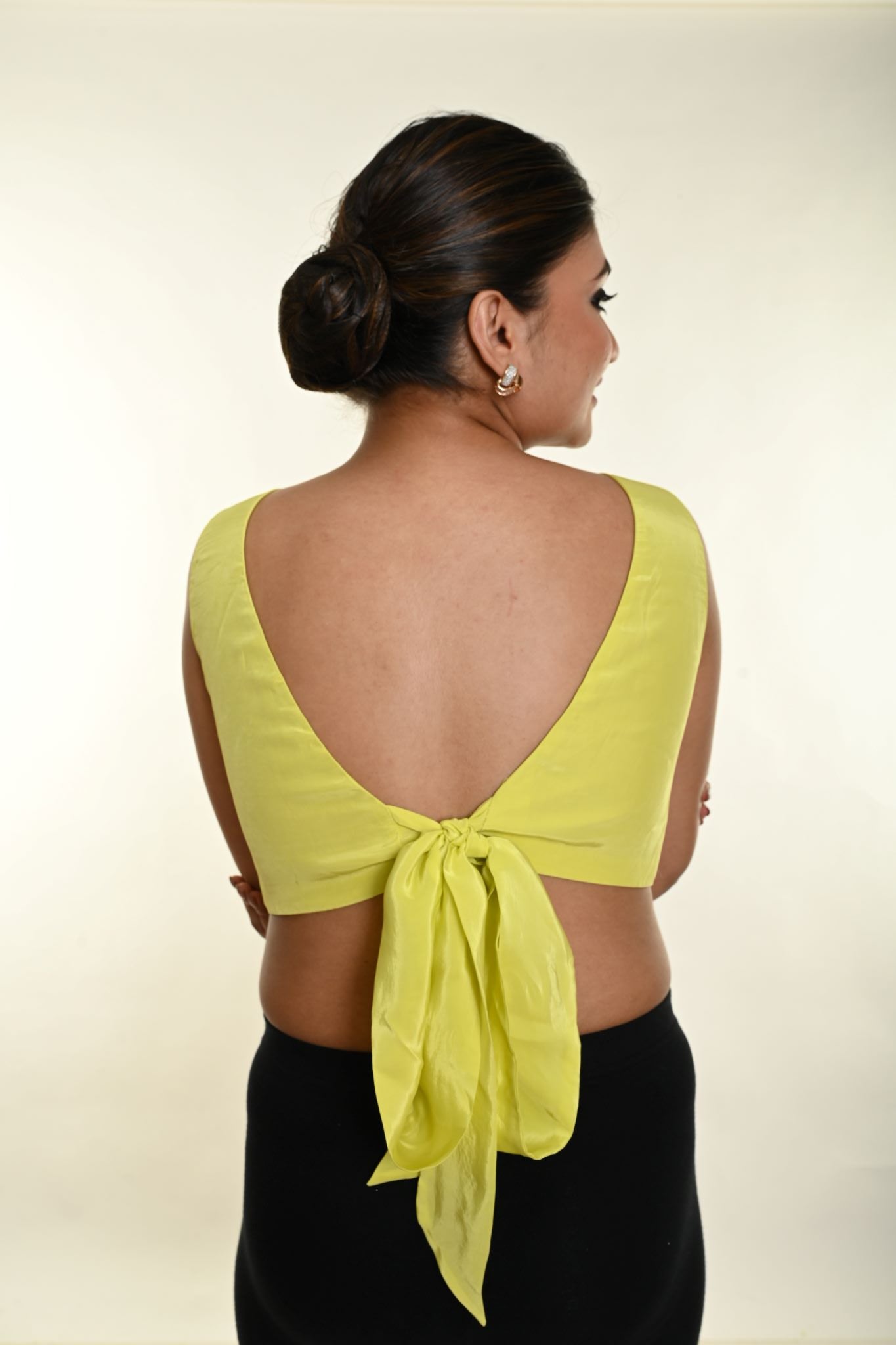 Back view of lemon yellow satin blouse with decorative bow tie-up detail - Anvi Couture