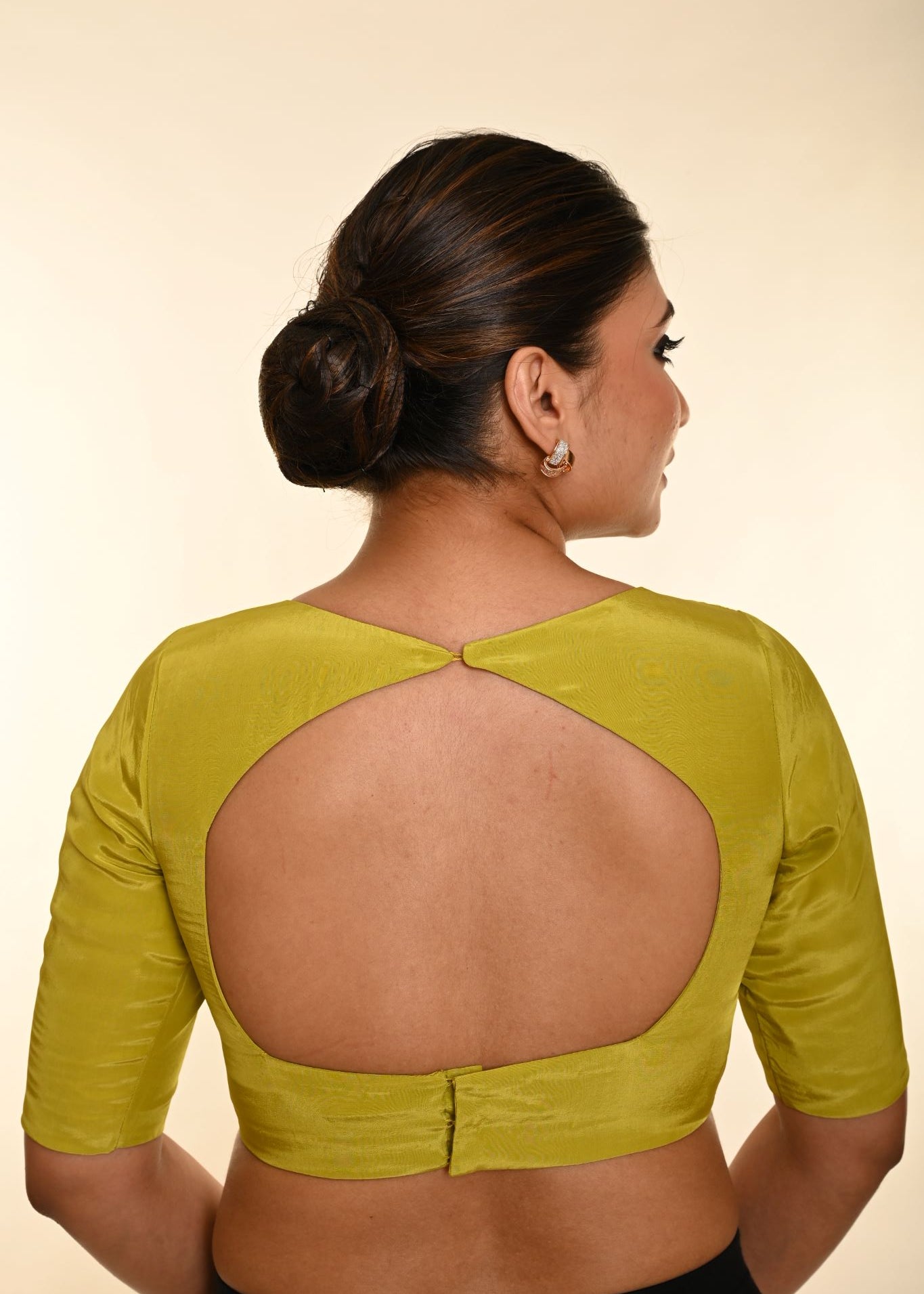 Back view of olive green silk crepe blouse showing boat neckline and hook closure