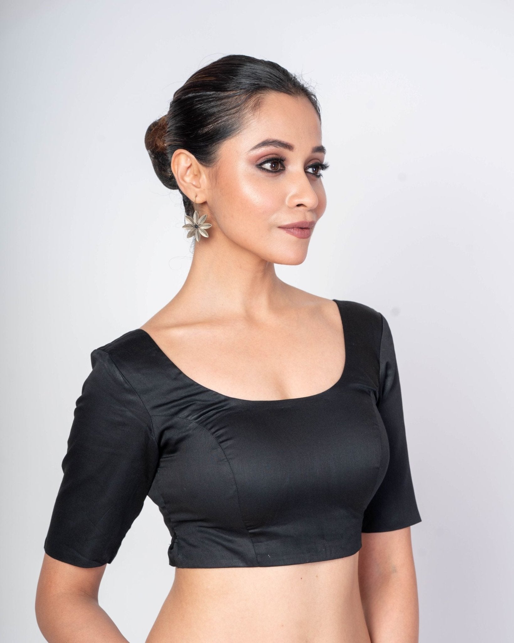 Modern black U-neck blouse styled with a silk saree for a sophisticated evening or formal event