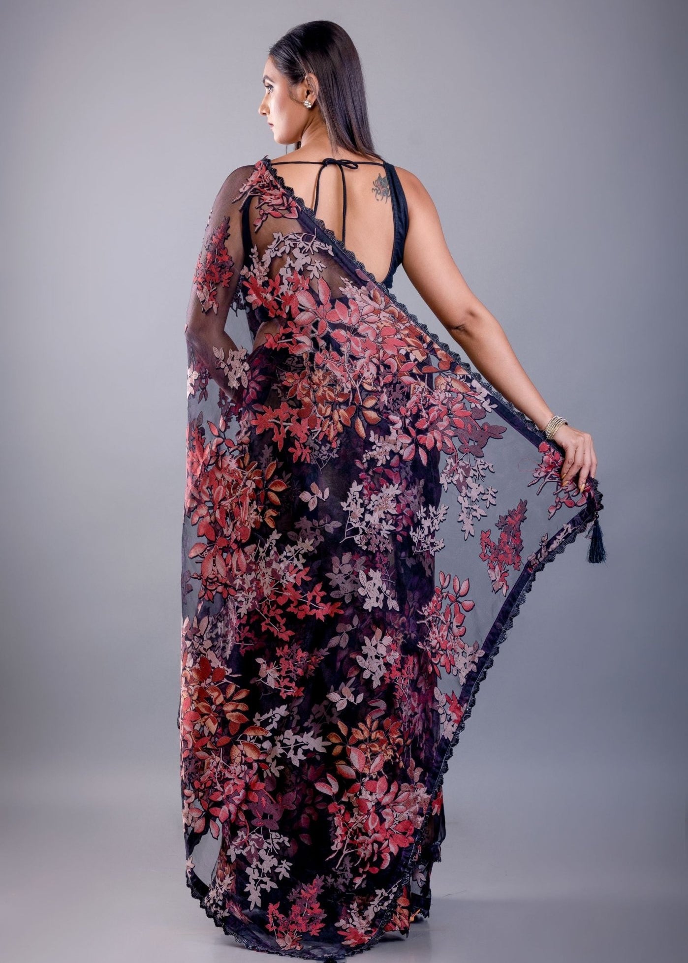 Black saree blouse design paired with sheer tissue party wear saree