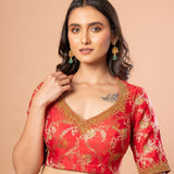 Close-up of aari embroidery work on red Banarasi brocade fabric