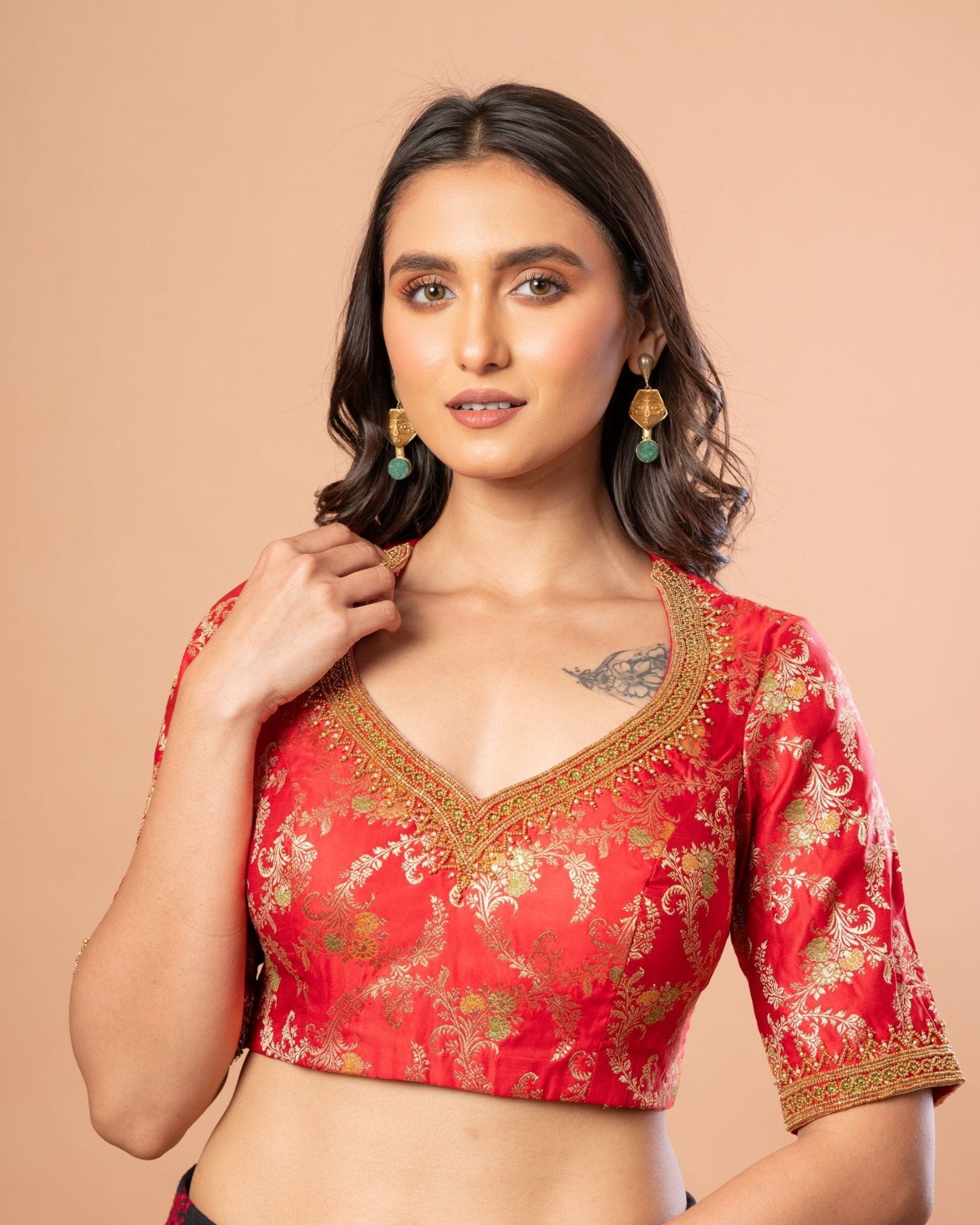 Close-up of aari embroidery work on red Banarasi brocade fabric