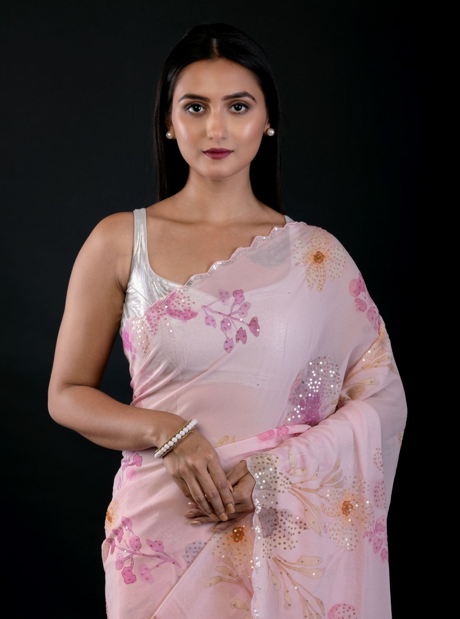 Close-up of floral embroidery and cutwork detail on light pink georgette saree by Anvi Couture