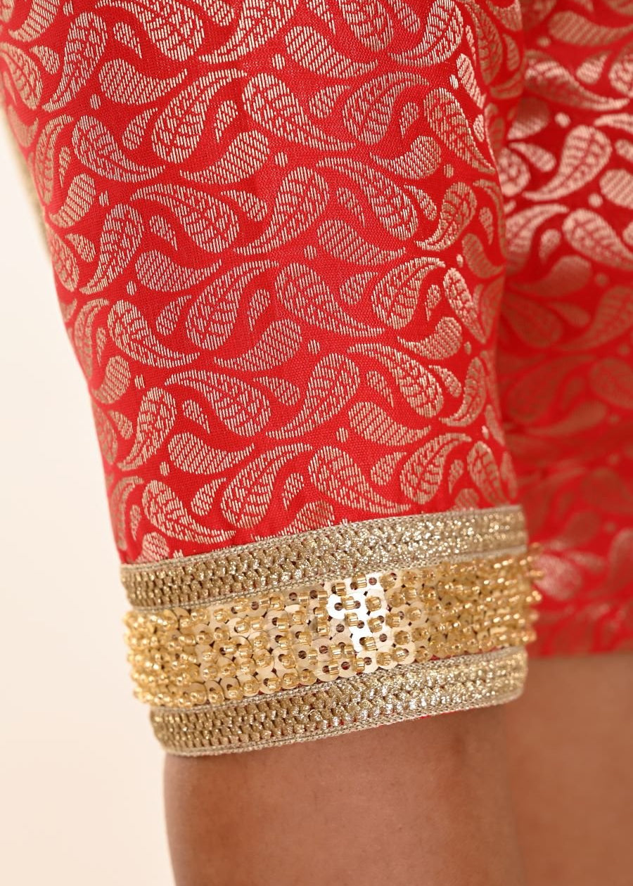 Close-up of gold embroidered border at elbow sleeve edge