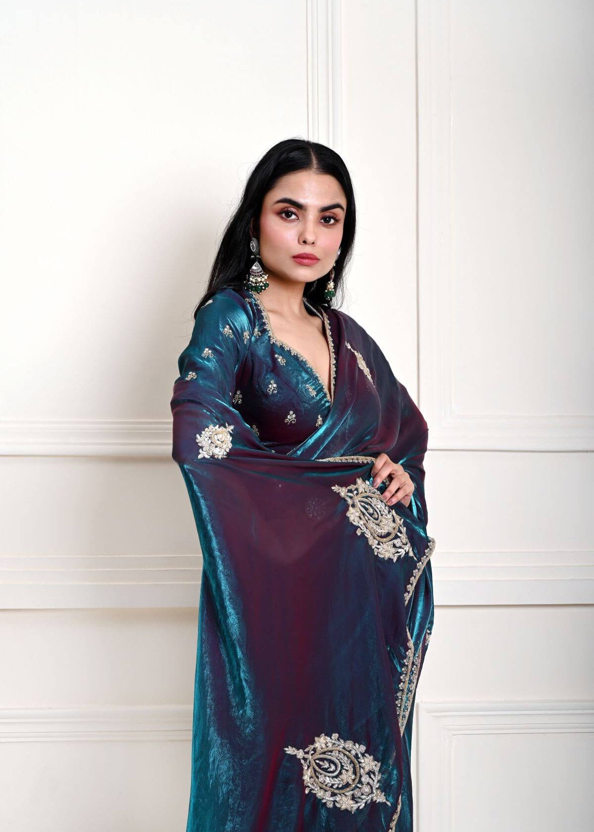 Close-up of hand embroidered floral work on the pallu of teal blue organza saree