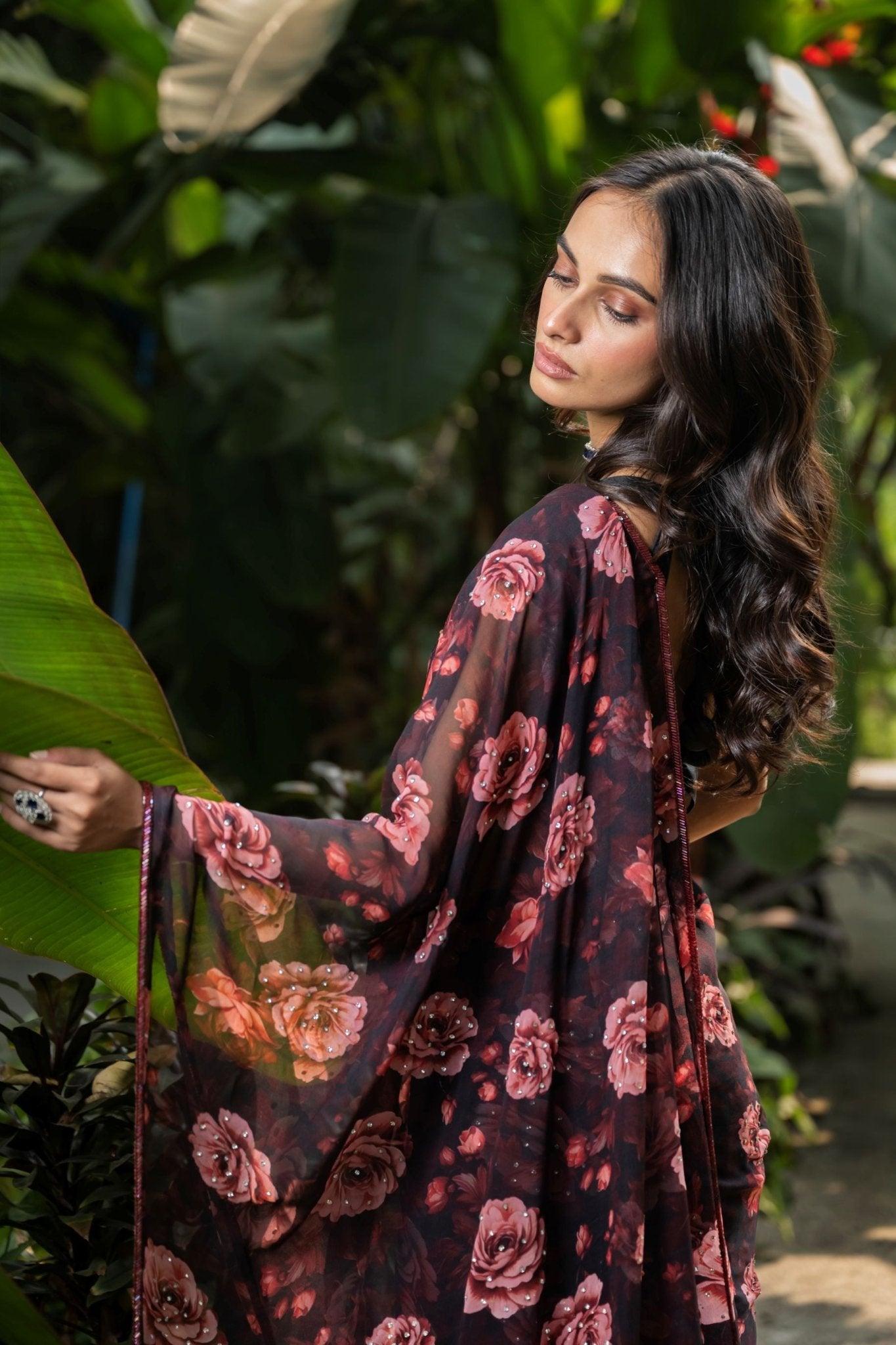 Close-up of stone embellishment and rose print on black georgette saree by Anvi Couture