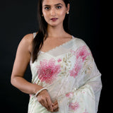Detail view of embroidered border and floral print on light green georgette saree by Anvi Couture