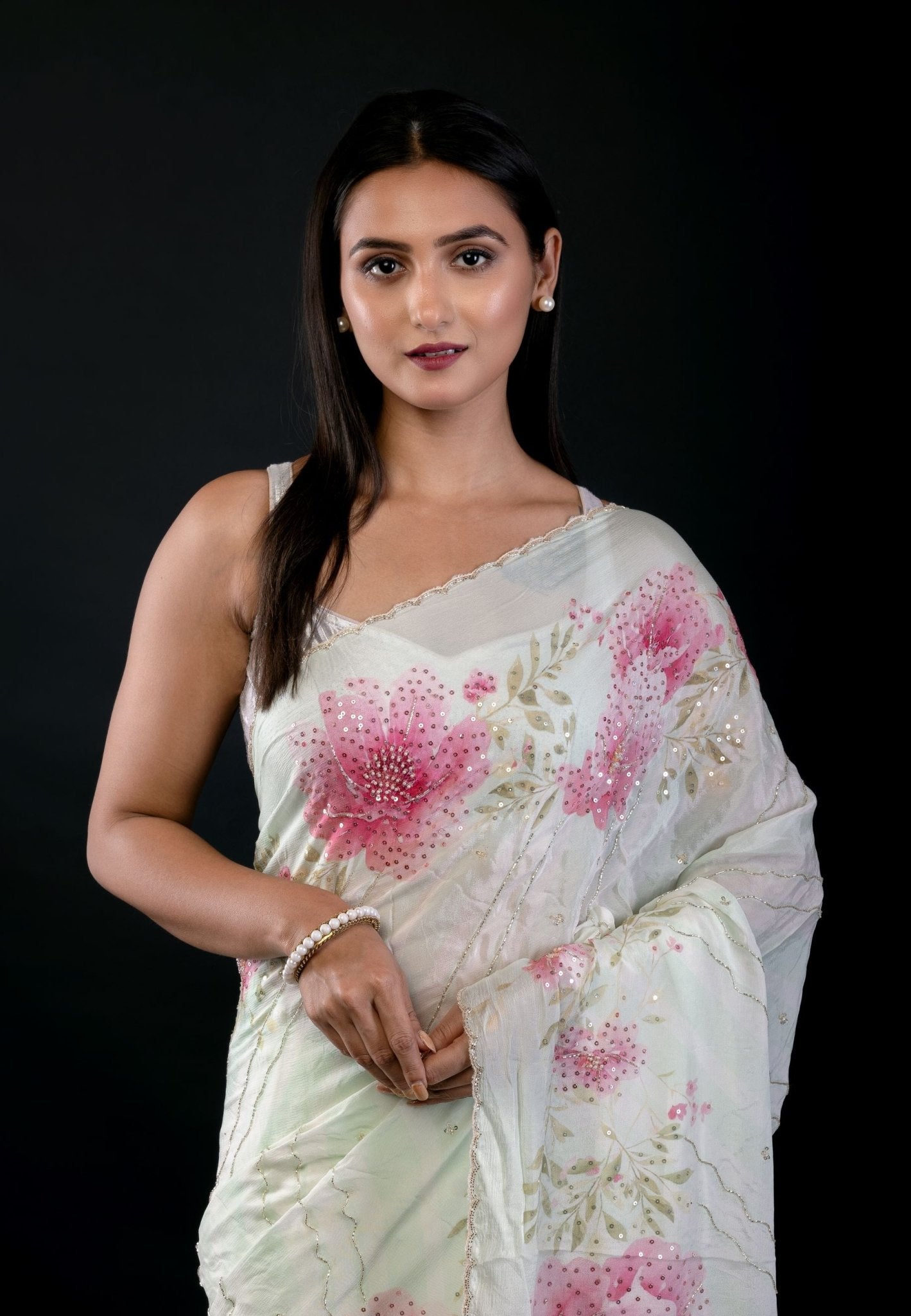Detail view of embroidered border and floral print on light green georgette saree by Anvi Couture