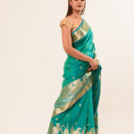 Woman wearing a light blue and gold temple border Katan Banarasi Silk Saree
