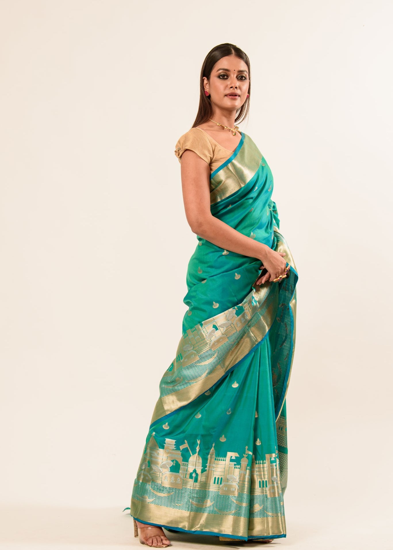 Woman wearing a light blue and gold temple border Katan Banarasi Silk Saree