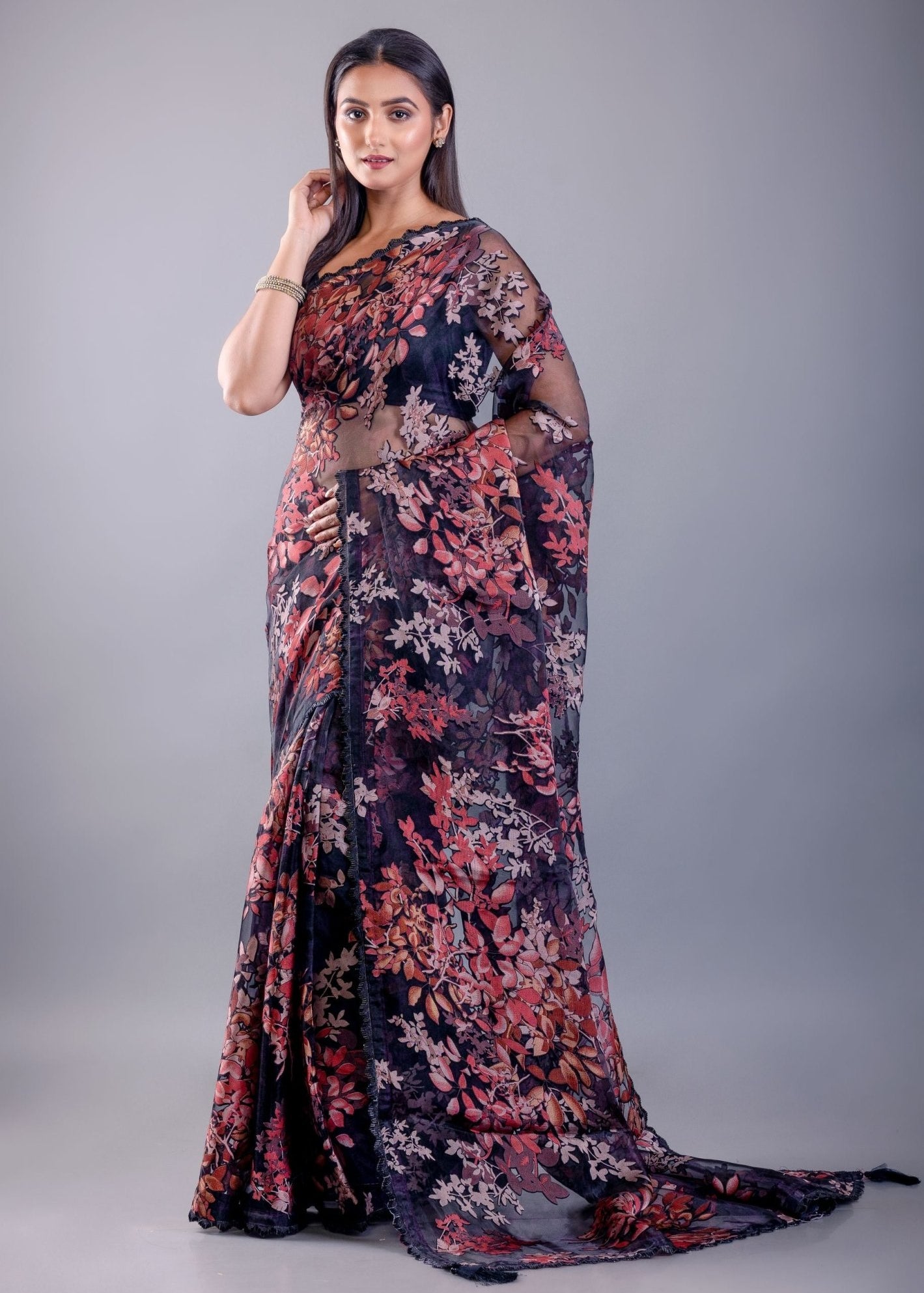 Model in black tissue silk saree with subtle sheer texture and all-over printed floral pattern, with delicate shimmer finish, shown with sample blouse — party and festive wear