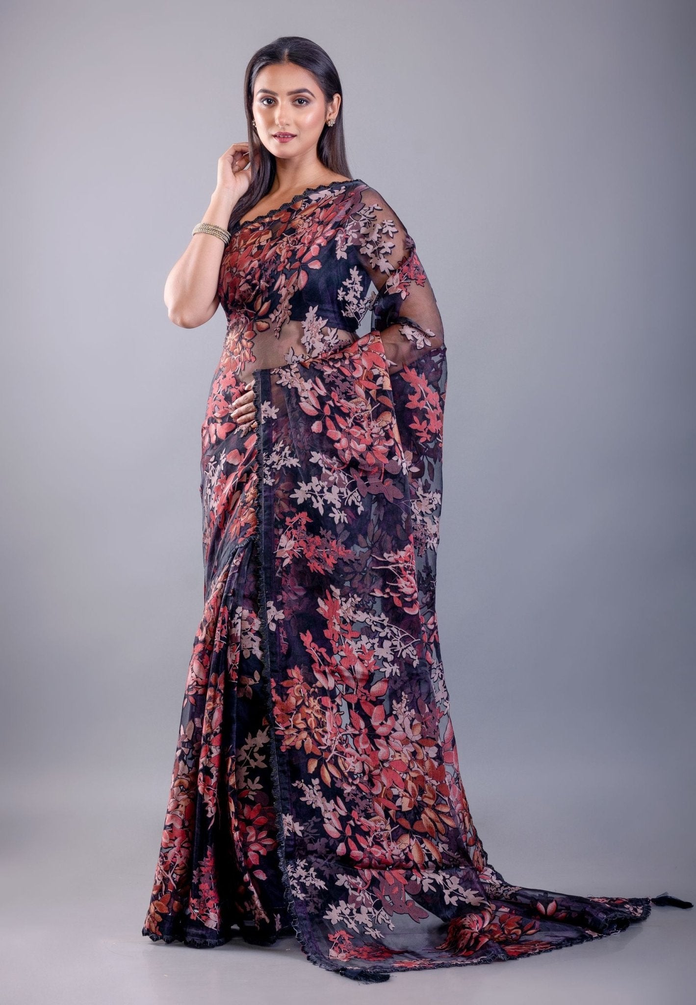 Model in black tissue silk saree with subtle sheer texture and all-over printed floral pattern, with delicate shimmer finish, shown with sample blouse — party and festive wear