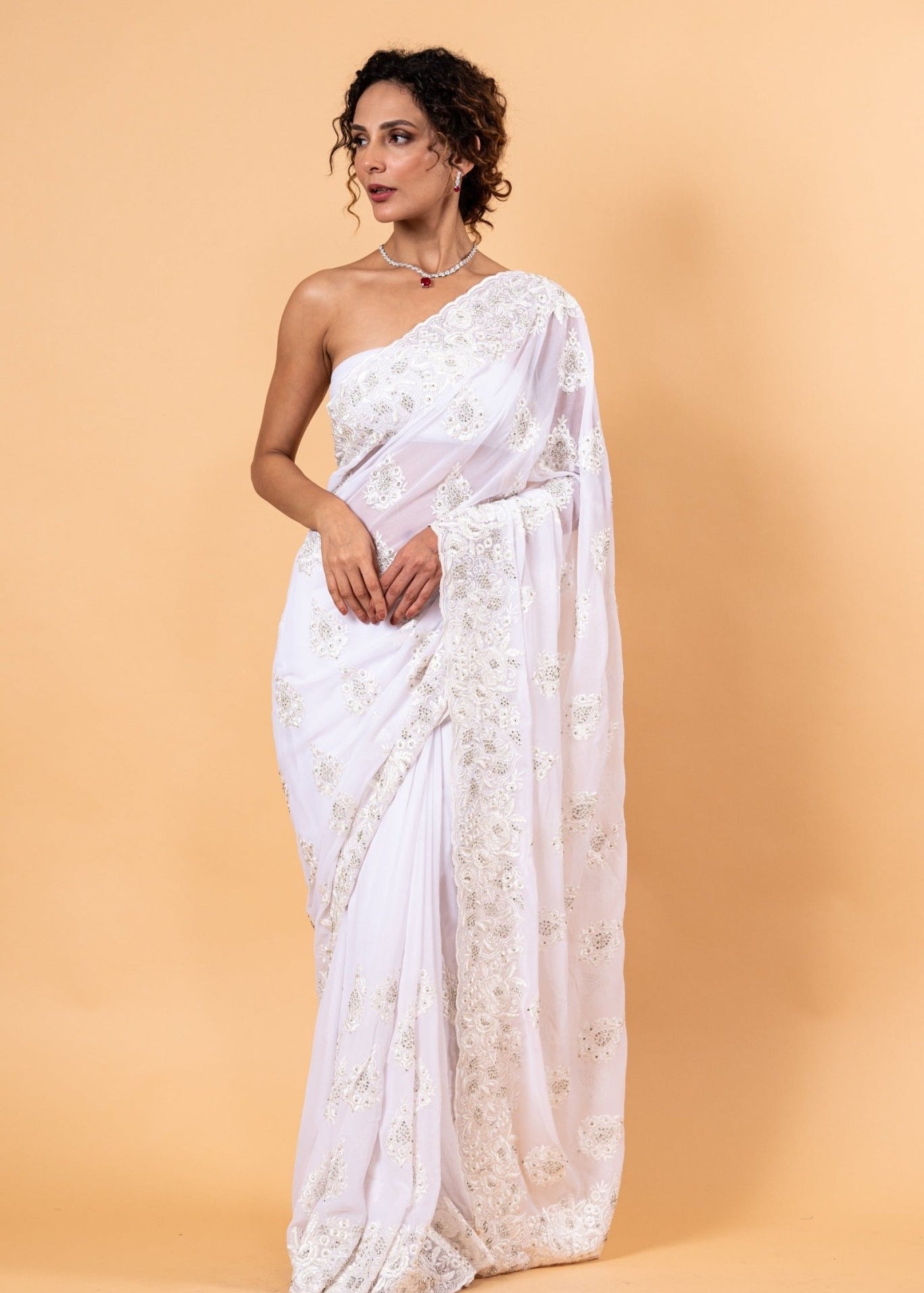 Sheer white net saree with delicate all-over white floral embroidery in resham thread and stone detailing, with unstitched blouse piece