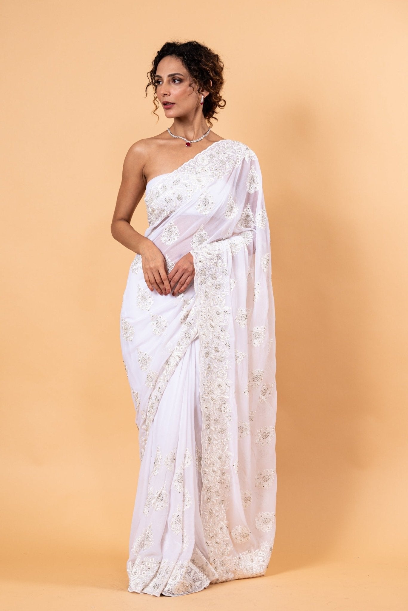 Sheer white net saree with delicate all-over white floral embroidery in resham thread and stone detailing, with unstitched blouse piece