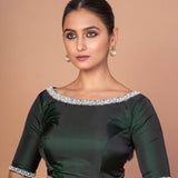 Side profile of dark green silk boat neck blouse with embroidered sleeves