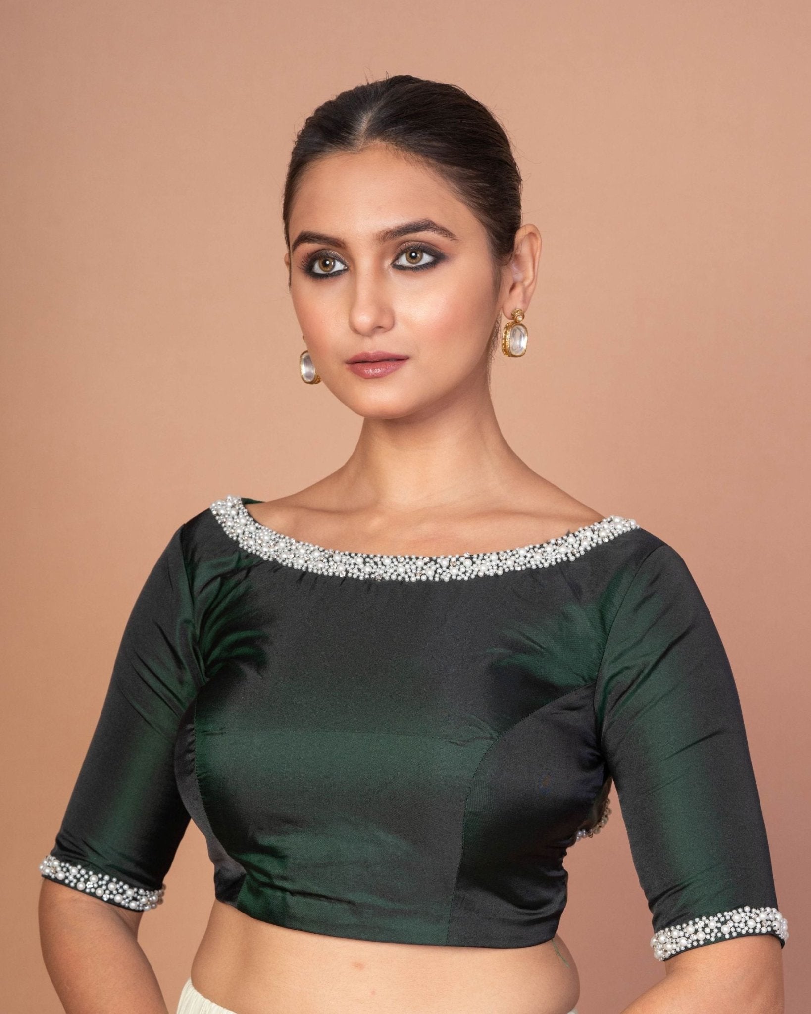 Side profile of dark green silk boat neck blouse with embroidered sleeves