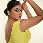 Side profile of lemon yellow satin boat neck blouse showing sleeveless silhouette