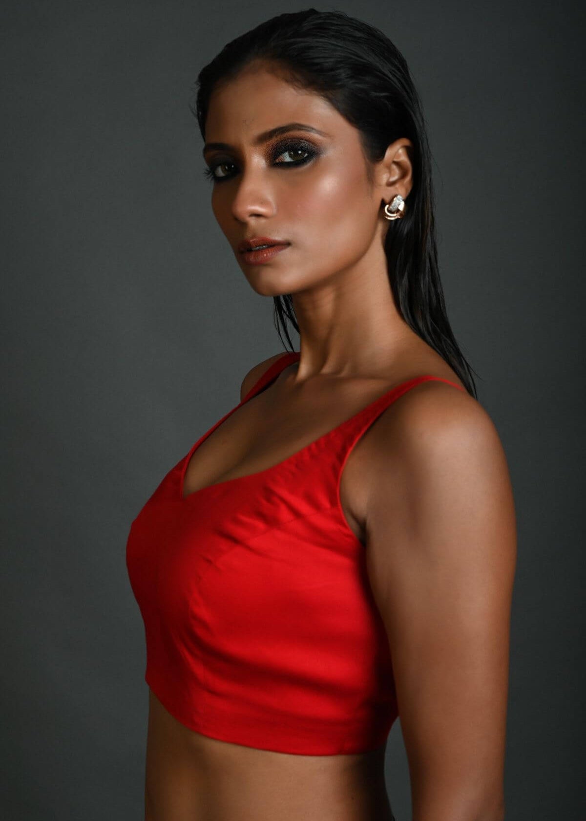 Side profile of red sleeveless cotton blouse with lightweight fabric design