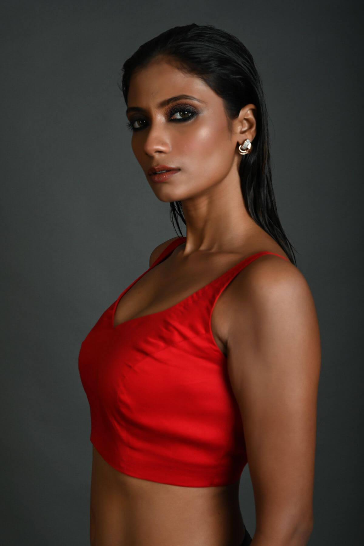 Side profile of red sleeveless cotton blouse with lightweight fabric design