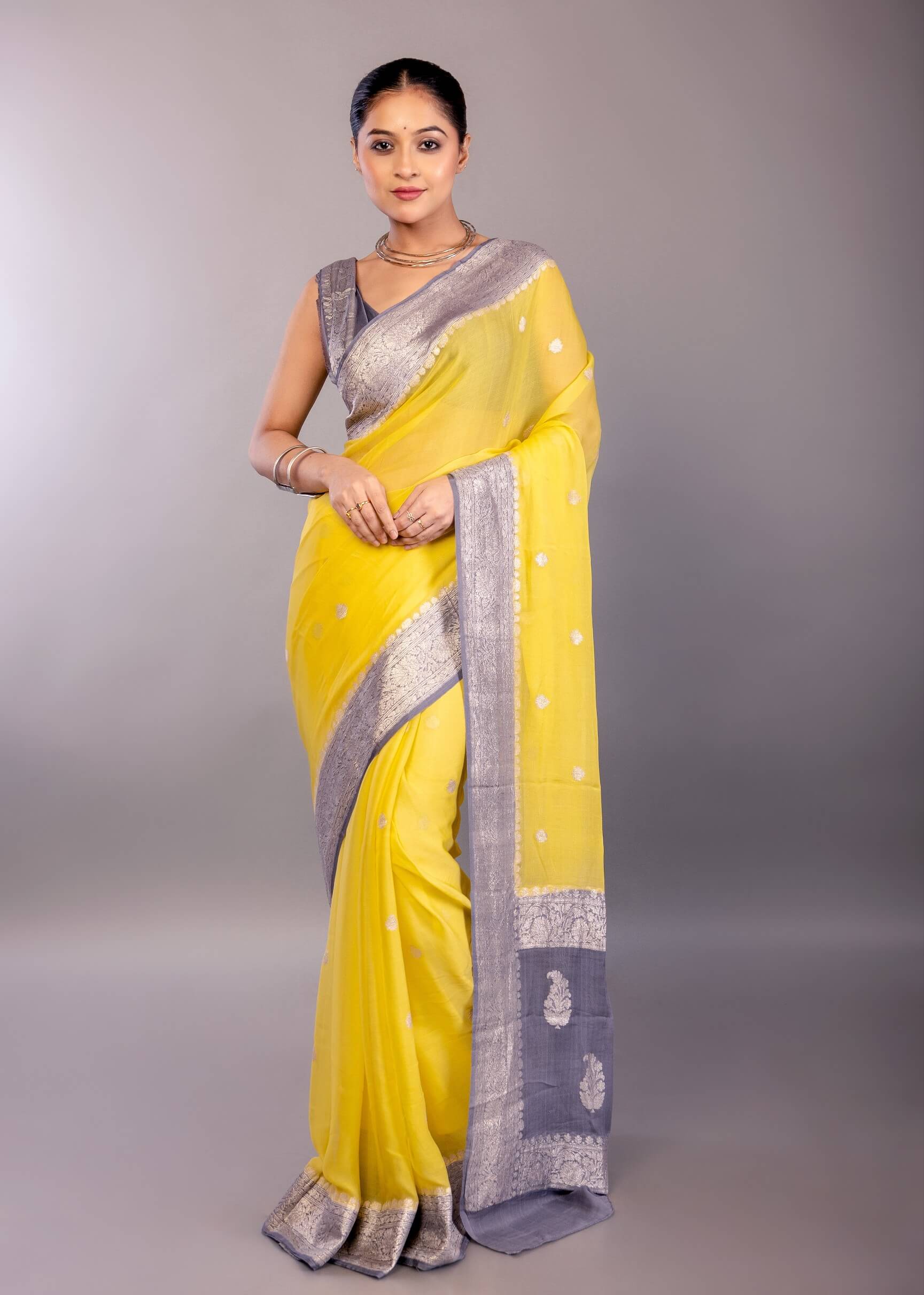 front drape view showing yellow georgette body with gray zari border