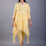 front view showing butter yellow dhoti pants and white tassel trim on kurta